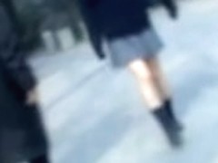 Naughty man sharking Asian college girl skirt in the street