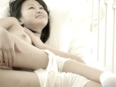 Beautiful Japanese girl Aliana lies on her back and fingers her peach