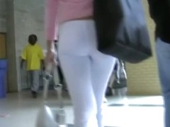 Fit brunette in white skintight pants walks in a student hall candid porn