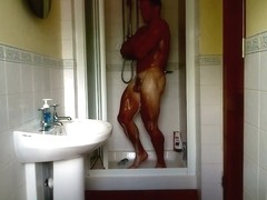 Muscle hunk Adam flexing in the bathroom showering