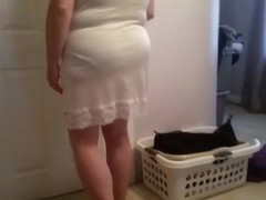 putting on her girdle, under garment over her big tits,
