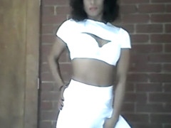 Sia in all white dancing, doing hair and playing with weights