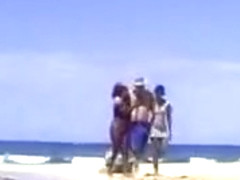 A lucky man on the beach with two ebony nymphs