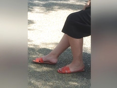 Candid Legs And Feet In Orange Sandals Of A Brunette Woman At The Bus
